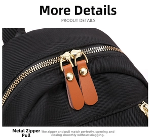 Detailed close-up of a golden metal zipper with brown leather pull and rivets on a black nylon bag
