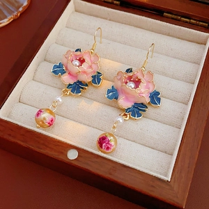 Macro view of vintage floral pearl earrings with pink enamel flowers and yellow rose beads