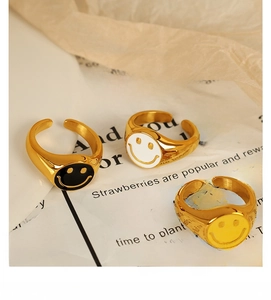Macro shot of three 18K gold-plated smiley face open rings with black and white enamel