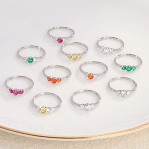 Set of 11 minimalist titanium steel rings with colorful zircon stones on white plate