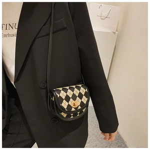 Detailansicht einer Mini-Satteltasche mit schwarz-weißem Karomuster und Goldverschluss
