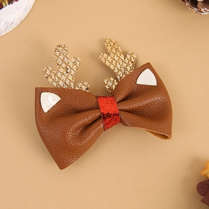 Detailed close-up of Christmas reindeer antler hair clips with glitter bow and bells