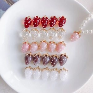 Macro detail of DIY resin strawberry pendants with pearls and golden rings in various colors
