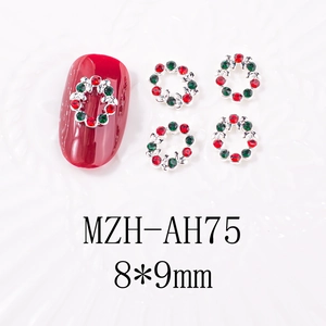 Détail d'un bijou d'ongle couronne de Noël 8x9mm avec strass rouges et verts