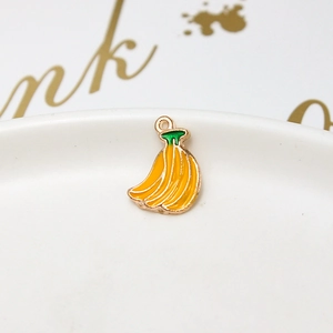 Macro shot of a handmade yellow enamel banana pendant with a gold alloy frame and top ring