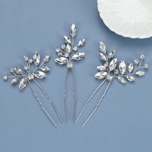 Detailed view of three silver leaf hair pins with sparkling clear crystals in a set