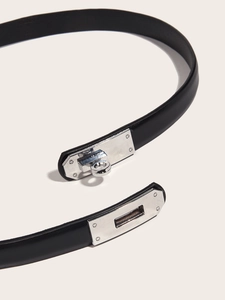 Detail of adjustable black leather belt with silver rotating metal lock buckle