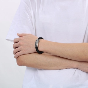 Men's leather bracelet featuring a silver lion head charm worn on a wrist in close-up