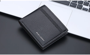 Close-up of black bifold wallet with wood texture and contrast stitching on laptop