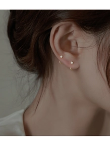Close-up of minimalist gold U-shaped earrings with micro-set zircon on model's ear