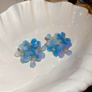 Detail of blue and purple gradient acrylic flower earrings with gold beaded centers