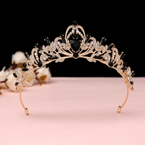 Macro shot of gold baroque crown with black teardrop gems and white rhinestones
