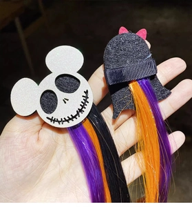 Detail of Halloween hair clips with spooky skull and witch hat styles with colored hair extensions
