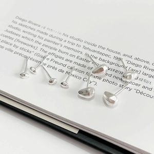 Three sizes of irregular organic 925 silver stud earrings on vintage book page