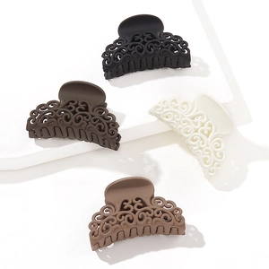 Hollow flower hair claws in matte black, brown, cream, and tan on a white background