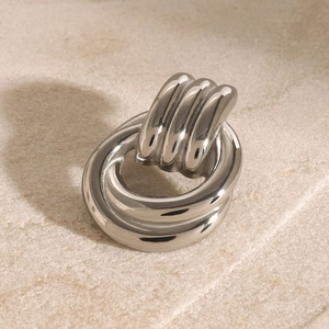 Macro view of geometric silver tiered brooch with high-polished metallic finish
