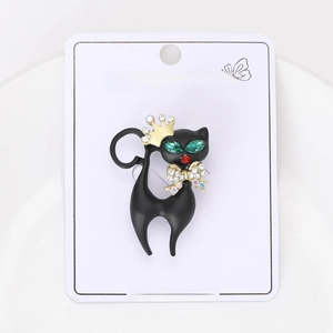 Detail view of a black enamel cat brooch with gold crown and sparkling crystal accents
