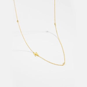 Detail of gold letter N pendant on a S925 sterling silver chain with three small zircons