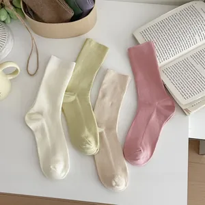 Flat lay of soft ribbed cotton crew socks in pastel white, green, beige and pink tones