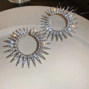 Macro view of silver starburst stud earrings with brilliant pavé crystal rhinestones