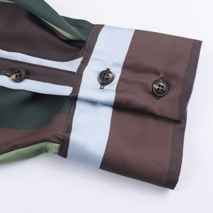 Detail of striped satin shirt cuff with dark tortoiseshell buttons and silk texture