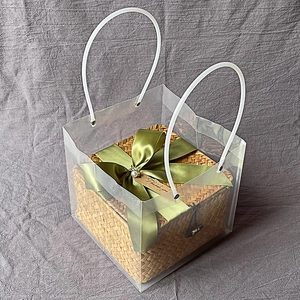 Square rattan gift basket in translucent PVC tote bag with elegant green ribbon
