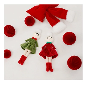 Flat lay detail of handcrafted plush Christmas doll ornaments in red and green velvet dresses