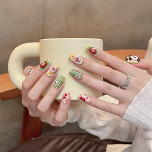 Press-on nails featuring green plaid, red florals, and festive Chinese character designs
