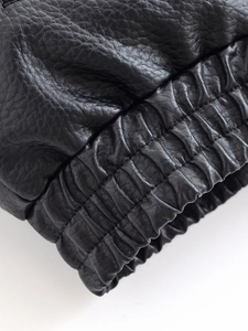 Vue macro du poignet élastique et texture grainée sur veste en cuir noir de qualité