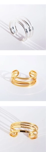 Close-up of geometric multi-layer open bracelets in polished gold and silver finishes