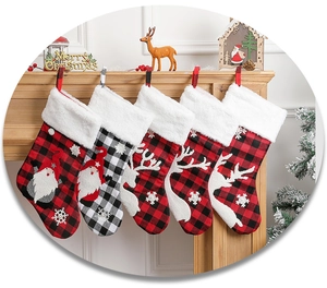 Close-up of plaid Christmas stockings with reindeer and Santa embroidery on wood mantel