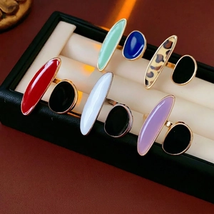 Colorful enamel oval rings in gold finish displayed in a luxury jewelry organizer