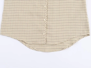 Detailed view of the plaid pattern fabric and white buttons on the curved hem of the shirt