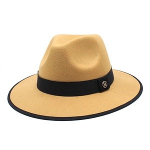 Close-up of camel wool fedora hat featuring black ribbon and golden M metal buckle