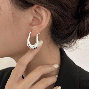 Minimalist 925 sterling silver U-shaped hoop earrings worn by a model in a side view