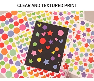 Detail of colorful star and heart stickers on light and dark backgrounds for DIY crafts