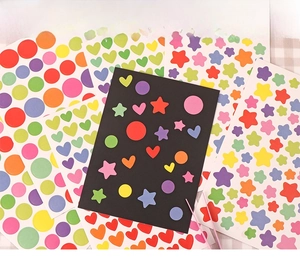 Detail of colorful star and heart stickers on light and dark backgrounds for DIY crafts