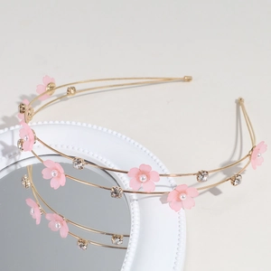 Detail of pink flower hairband with pearls and rhinestones on a gold metal base