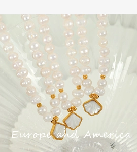 Macro shot of three freshwater pearl bracelets with golden shell charms on a glass