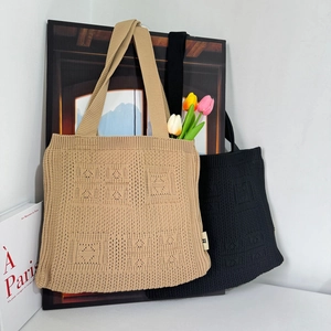 Close-up of khaki and black knitted tote bags with hollow texture and fresh tulips