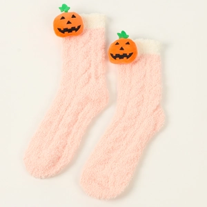 Nahaufnahme der rosa flauschigen Chenille-Socken mit orangefarbenem Kürbis-Dekor