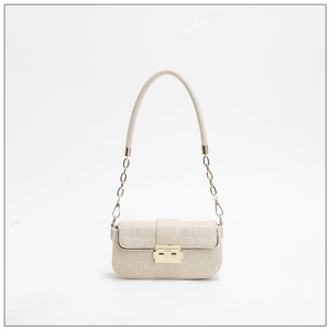 Detail of cream white faux crocodile leather handbag with gold geometric lock and chain