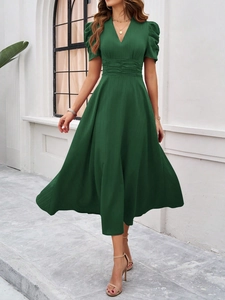 Detailed close-up showing the elegant V-neckline and ruched waist of this green dress