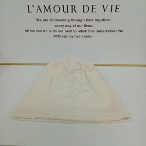 Close-up of cream knit beanie with 3D geometric embossed texture and lightweight design