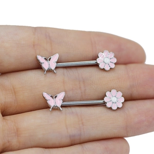 Detailed close-up of pink butterfly and flower piercing jewelry on a finger