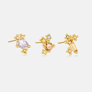 Detailed close-up of three gold earrings featuring colorful pear, round and square stones