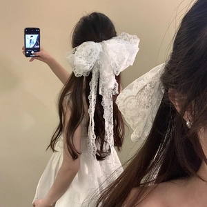 Eleganter übergroßer weißer Spitzen-Haarclip mit langen Bändern auf gewelltem Haar