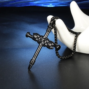 Détail d'un pendentif croix en acier titane noir avec design vis sur main en céramique