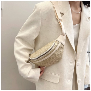 Detail of woven straw waist bag with cream PU trim and adjustable strap on a beige blazer