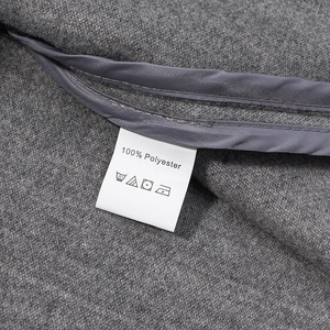 Close-up of gray wool coat fabric with 100% polyester wash care label detail